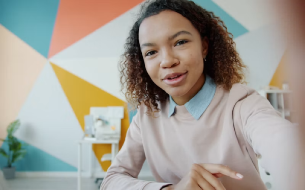 Close-up portrait of a smiling woman speaking against a colorful background